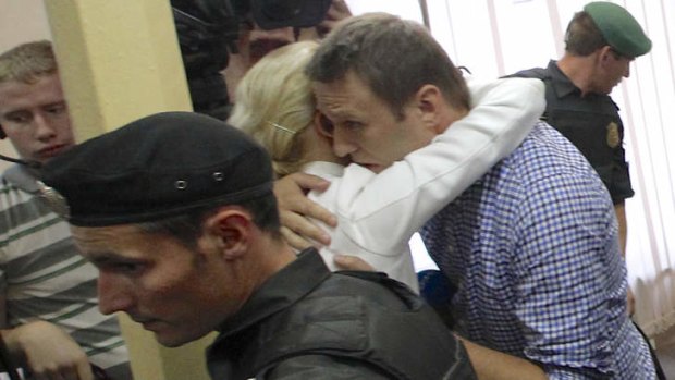 High profile case: Russian opposition leader Alexei Navalny embraces his wife Yulia as he is led away.