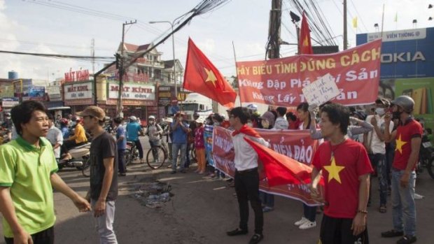 Workers wave Vietnamese flags at a demonstration in an industrial zone in Binh  Duong province on Wednesday.