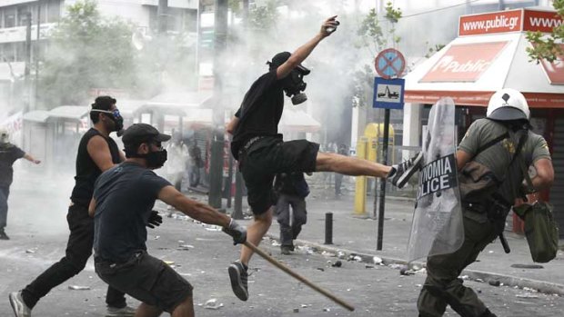 Greek protestors fight police as the parliament votes in favour of a new austerity package.