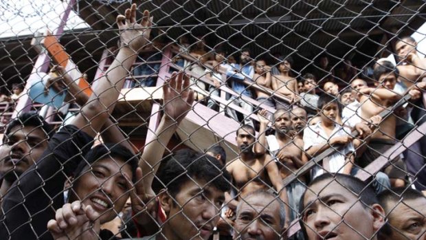 Detainees press up against a fence in a detention center on the outskirts of Kuala Lumpur, Malaysia.