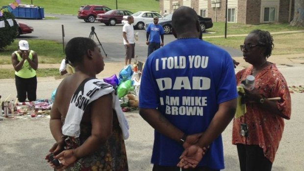 Michael Brown's father talks to well-wishers at a makeshift memorial set up to honour his son.