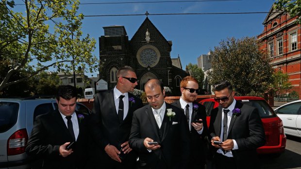 Groom Chris LaMacchia and his attendants check the score on grand final day.