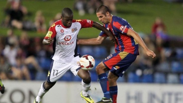 Bruce Djite of Adelaide contests the ball with Josh Mitchell of the Jets.