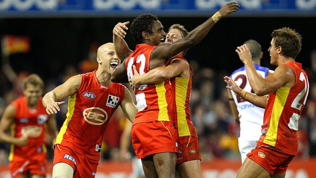 Suns shining: Gold Coast’s Liam Patrick is jubilant as he celebrates a goal with his ecstatic teammates.