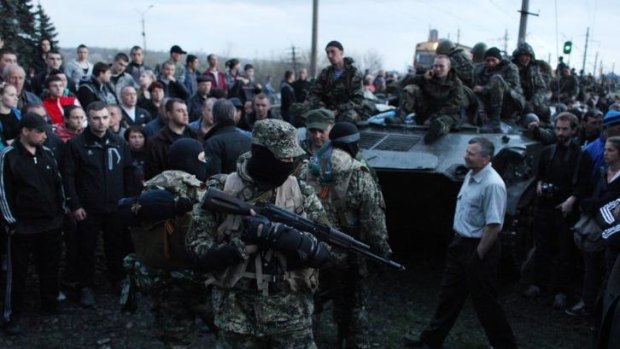 Pro-Russia activists block Ukrainian soldiers riding on armoured vehicles in Kramatorsk.