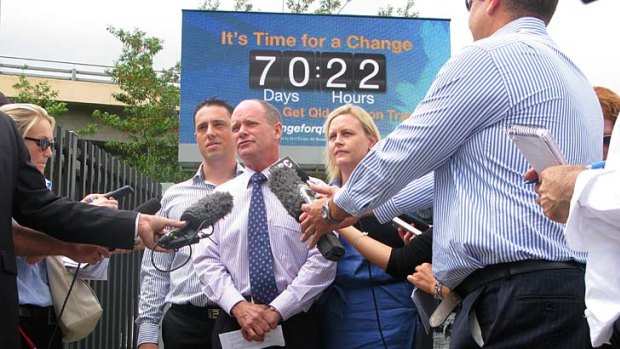 LNP leader Campbell Newman speaks with reporters in front of a clock counting down to the opposition's predicted election date.