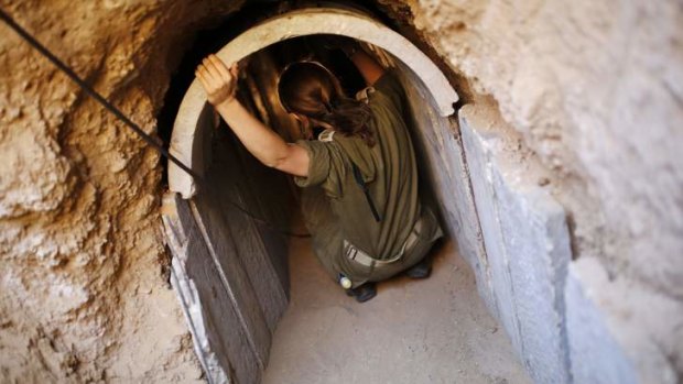 An Israeli soldier squats in a tunnel exposed by the Israeli military near Kibbutz Ein Hashlosha, just outside the southern Gaza Strip.