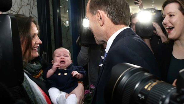 Opposition Leader Tony Abbott meets with 4-month-old Sybil Taylor and Charlotte Taylor during his visit to a cafe in Malvern, Victoria.