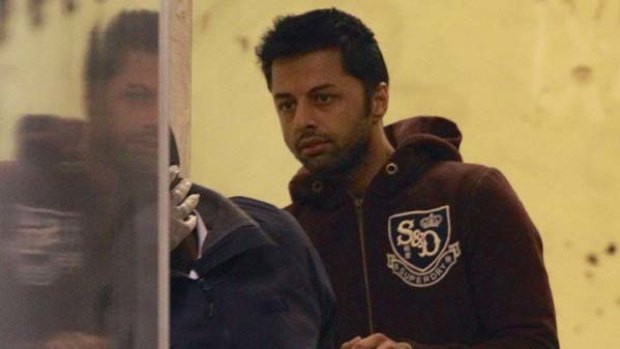 Facing extradition ... Shrien Dewani is led to a prison van after his court appearance in London.