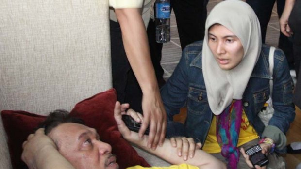 The Opposition leader, Anwar Ibrahim, lies injured at a rally.