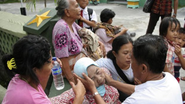 Shaken...a man comforts a relative in Padang.