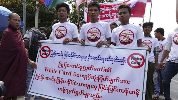 Activists hold a placard that reads "We strongly oppose the decision of Parliament on white card holders to vote in a referendum".