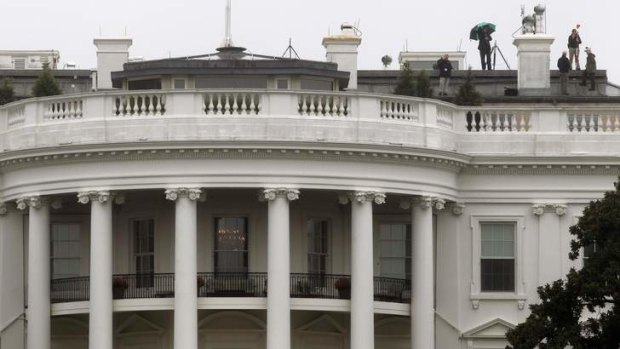 A crew works atop the White House on the side that was hit by bullets in November, 2011. A man has pleaded guilty to the shooting.