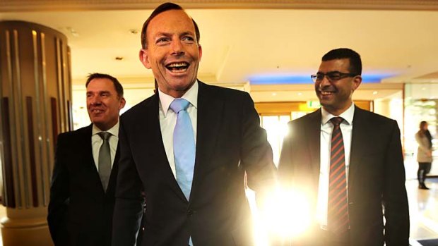 Prime Ministerial smile: Tony Abbott puts a brave face on things on Friday.