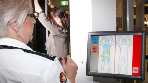 A passenger being screened by a body scanner.