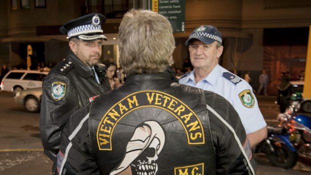 Outlaw Motorcycle Club members gather on Bayswater road as police look on.