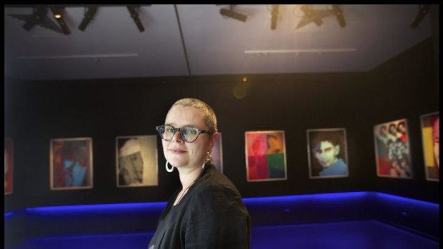 Jewish Museum of Australia director Rebecca Forgasz with portraits from Andy Warhol's <i>Jewish Geniuses</i> series.
