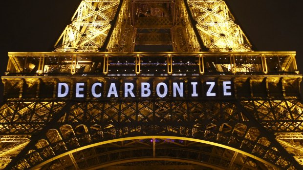 The slogan "DECARBONIZE" is projected on the Eiffel Tower as part of the COP21, United Nations Climate Change Conference in Paris, France, Friday, Dec. 11, 2015. (AP Photo/Francois Mori)