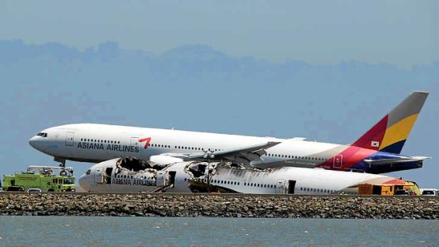 An Asiana Airlines plane flies over the wreck of Flight 214.