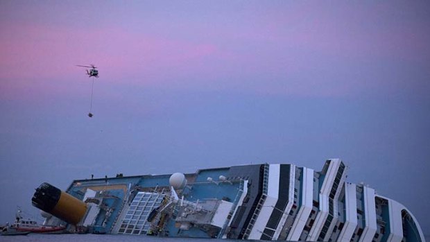 A helicopter approaches the wreck of the Costa Concordia cruise ship.