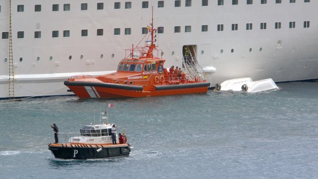 An orange rescue boat is seen docked by a capsized lifeboat in Santa Cruz port of the Canary Island of La Palma, Spain.