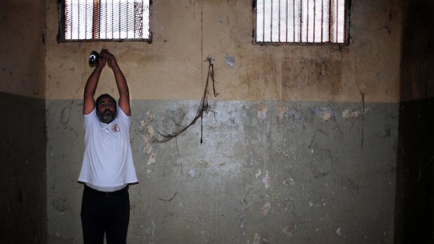 Ashraf Sueden shows how he was tortured inside Tripoli's Abu Salim prison.