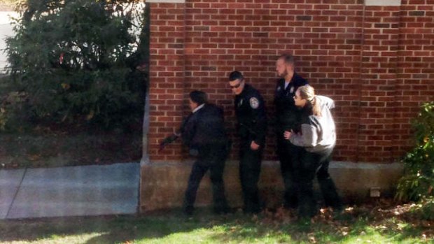 In this photo taken through a window, police officers respond  to a report of a suspicious person at Central Connecticut State University in New Britain, Connecticut on Monday.
