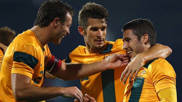 Matthew Leckie (right) of Australia celebrates with captain Lucas Neill after scoring.