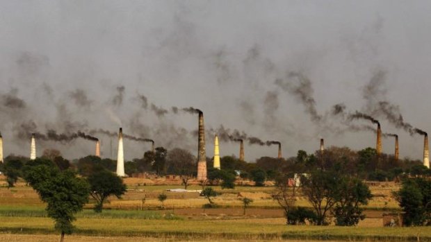 Chimneys of brick kilns emit smoke on the outskirts of New Delhi, India. Countries around the world have been missing their CO2 emissions targets.