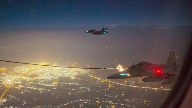 Two RAAF F/A-18F Super Hornet aircraft conduct air to air refuelling with a RAAF tanker aircraft by night over Iraq. 