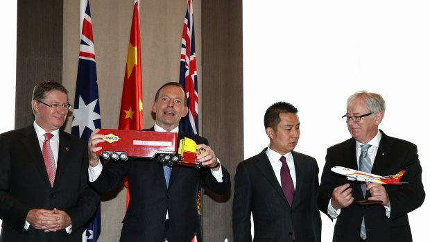 Prime Minister Tony Abbott, Huang Gan, executive director of HNA Group, and Minister for Trade and Investment, Andrew Robb during a visit to Shanghai in 2014. 