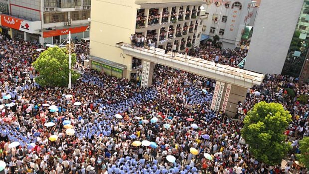 Battling against pollution ... protesters and police outside the local government offices in Qidong.