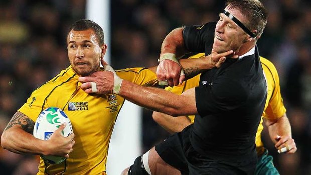 Stop right there ... Quade Cooper tries to fend off the relentless grip of All Black Brad Thorn.