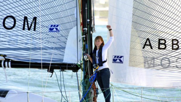 Abby Sunderland waves aboard her boat, Wild Eyes.