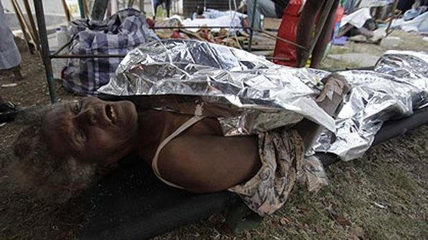Ms Zizi, 69, lies on a stretcher after being pulled from the rubble of the collapsed cathedral.