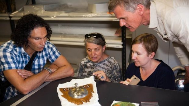 Artists Brett Graham, Olga Cironis, Sera Waters and Nicholas Folland examine a work of trench art made by Sapper Stanley Keith Pearl.