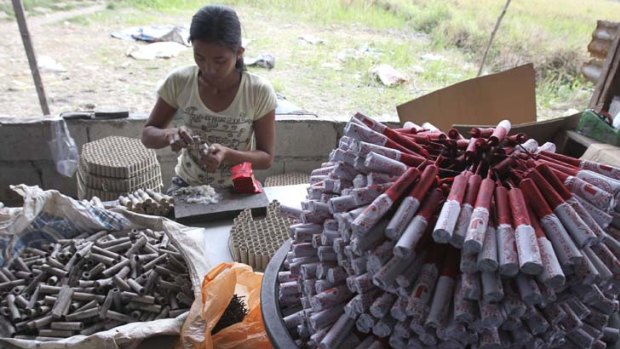 A woman makes firecrackers in a backyard factory in Bocaue, north of Manila.