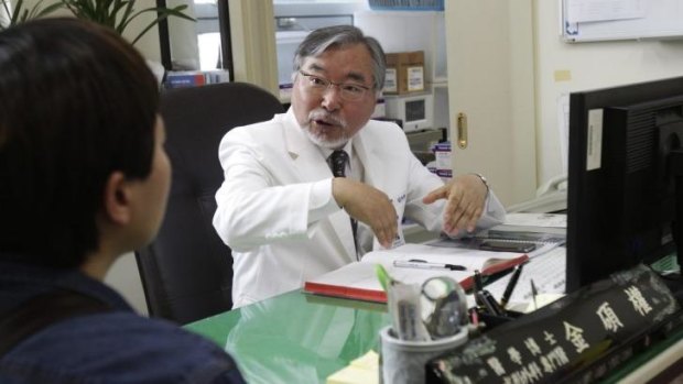 Dr Kim Seok-Kwun, 61, talks with an unidentified patient at Dong-A University Hospital in Busan, South Korea.