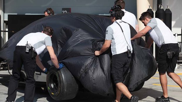 Kevin Magnussen's Formula One car is pushed into the McLaren garage.
