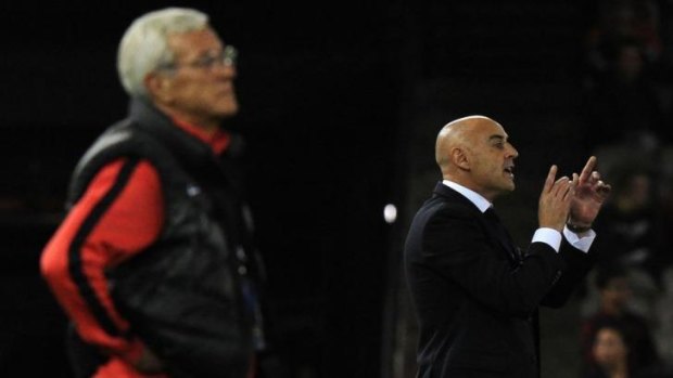 Guangzhou Evergrande coach Marcello Romeo Lippi (left) watches the game as Melbourne Victory coach Kevin Muscat shouts instructions to his players.