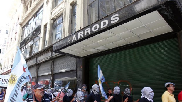 Argentine demonstrators march past an abandoned Harrods store in Buenos Aires, last February.