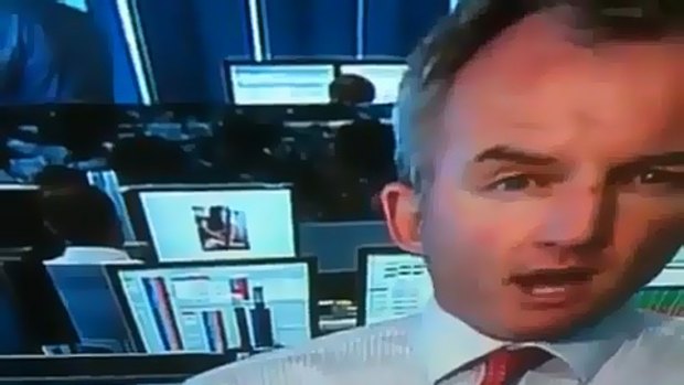 Martin Lakos during the live cross from Macquarie Bank with a naked woman visible on the computer screen behind.