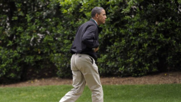 Call to action ... Barack Obama races off the golf course still wearing his spikes to get back for the attack.