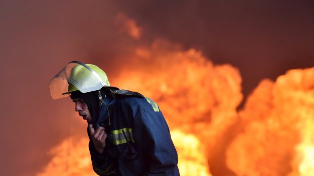 A Ukrainian firefighter retreats from the fire at the fuel depot outside Kiev.