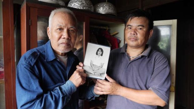 Sukham Panjoy and son Banjong Panjoy hold a picture of Anocha, Sukham's sister, taken a year before she was abducted in 1978.