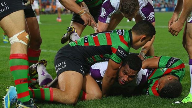 Sisa Waqa of the Storm is held up over the line by Dylan Farrell of the Rabbitohs during the qualifying final on September 13.