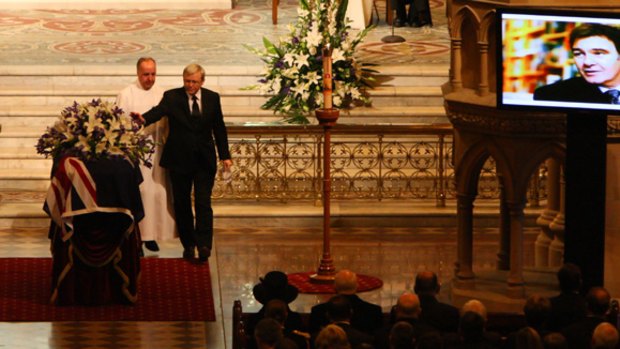Kevin Rudd reaches out to Chris O'Brien's coffin during his state funeral yesterday.