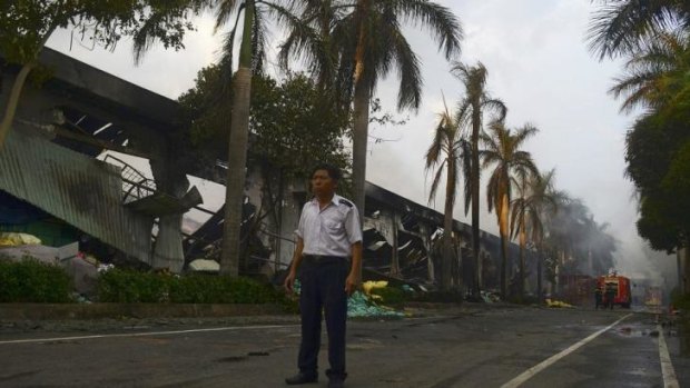 A security guard stands near a damaged shoe factory in Vietnam's Binh Duong province.