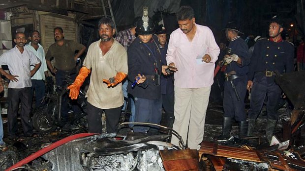 Bomb blast ... policemen inspect the site of an explosion at Zaveri Bazaar.