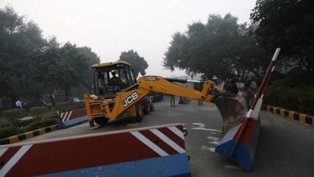 A bulldozer removes the security barriers in front of the US embassy in Delhi. 